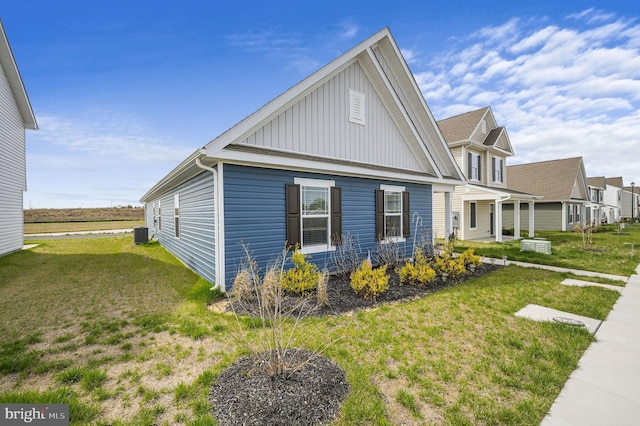 10883 Farmerfield St, Milford, DE 19963 - view of home's exterior featuring board and batten siding, a lawn, and central AC unit