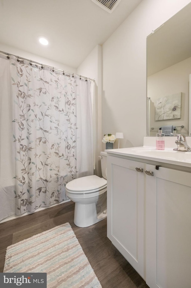 10883 Farmerfield St, Milford, DE 19963 - bathroom featuring wood finished floors, vanity, toilet, visible vents, and recessed lighting