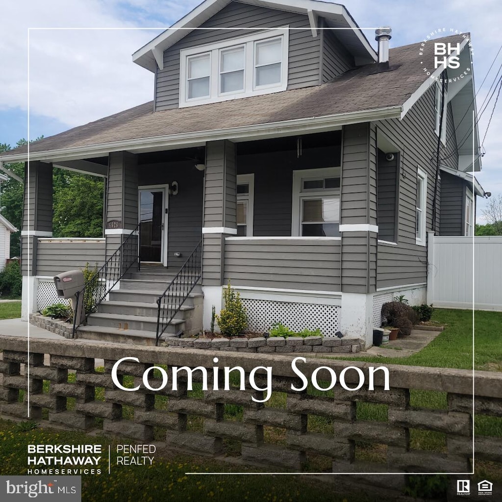 bungalow with a porch, fence, and a shingled roof