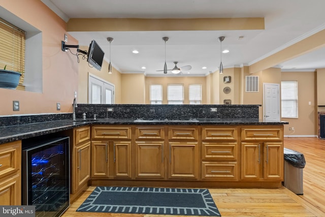 4626 Kavon Ave, Baltimore, MD 21206 - kitchen with wine cooler, light wood finished floors, ceiling fan, a sink, and crown molding