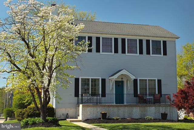 colonial home featuring a front lawn