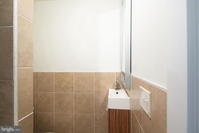 bathroom with tile walls and vanity