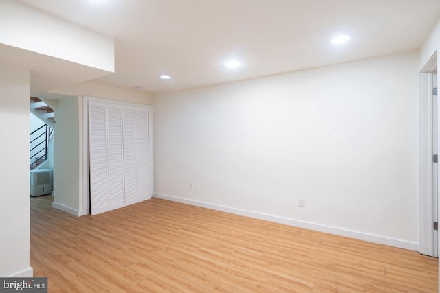 unfurnished bedroom with light wood-style flooring, baseboards, recessed lighting, and a closet