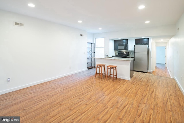 kitchen with baseboards, visible vents, recessed lighting, light wood-style floors, and black appliances