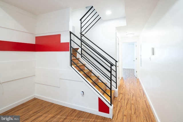 stairway featuring baseboards and wood finished floors