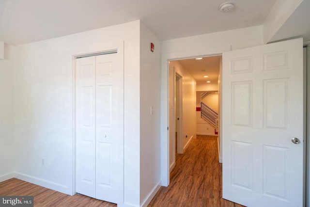 hallway with wood finished floors and baseboards
