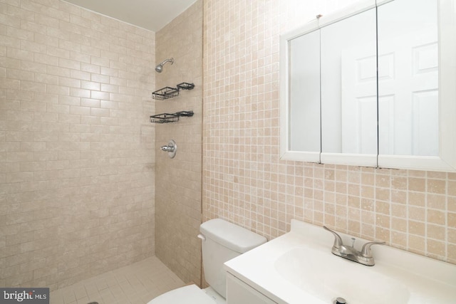 full bathroom featuring tiled shower, toilet, and tile walls