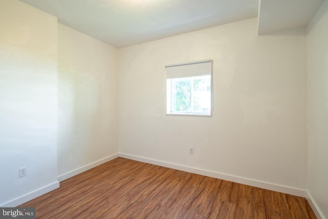 unfurnished room featuring baseboards and wood finished floors