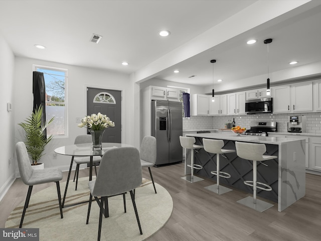 3833 Reisterstown Rd, Baltimore, MD 21215 - dining space with recessed lighting, baseboards, visible vents, and light wood-style floors
