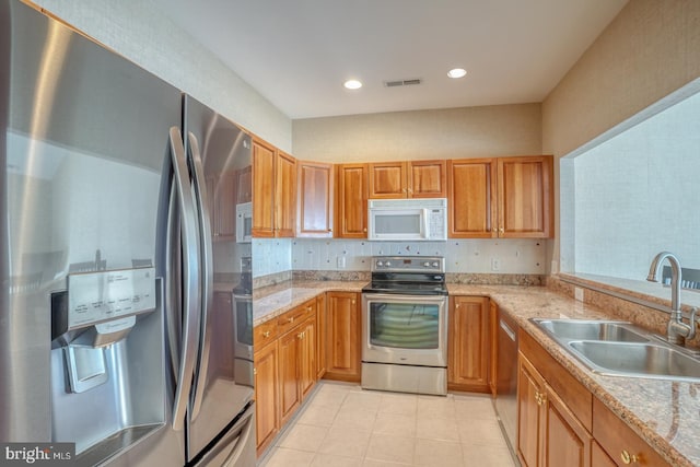 11 Marina View Ct Unit A-6, Bethany Beach, DE 19930 - kitchen with light tile patterned flooring, light stone counters, a sink, stainless steel appliances, and visible vents