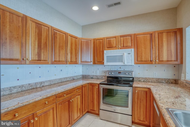 11 Marina View Ct Unit A-6, Bethany Beach, DE 19930 - kitchen featuring appliances with stainless steel finishes, brown cabinetry, and visible vents