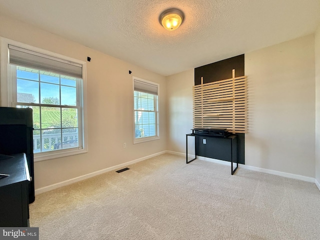 unfurnished bedroom featuring a textured ceiling, visible vents, and baseboards