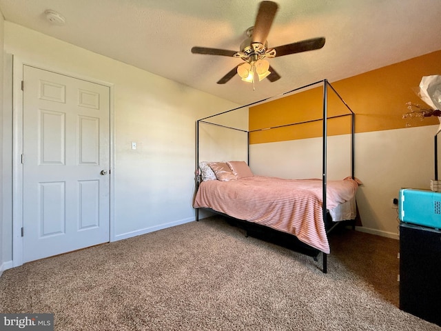 carpeted bedroom with ceiling fan and baseboards