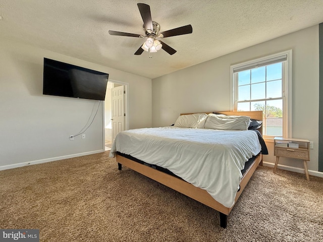 carpeted bedroom featuring baseboards, ensuite bath, a ceiling fan, and a textured ceiling