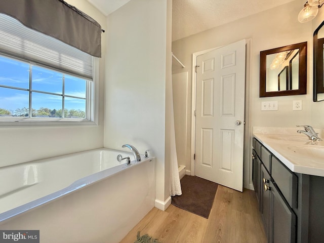 full bath with wood finished floors, a bath, vanity, baseboards, and curtained shower