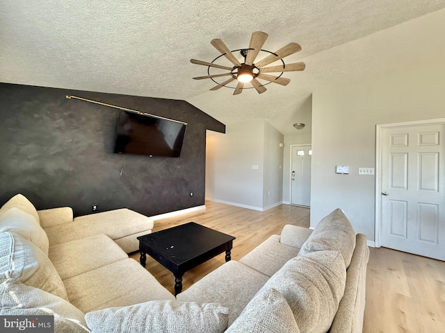 living room with a textured ceiling, wood finished floors, a ceiling fan, and baseboards