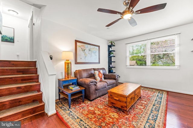 living room with baseboards, a ceiling fan, stairs, and hardwood / wood-style flooring