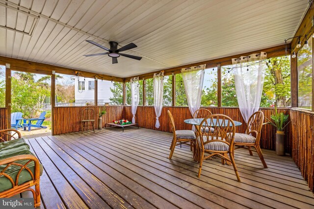 sunroom featuring outdoor dining area and ceiling fan