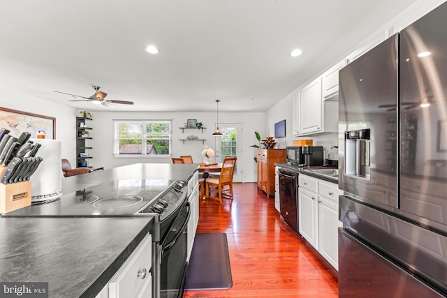 kitchen featuring white cabinetry, dark countertops, ceiling fan, and black appliances