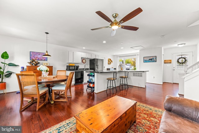 living room featuring recessed lighting, ceiling fan, dark wood finished floors, and baseboards