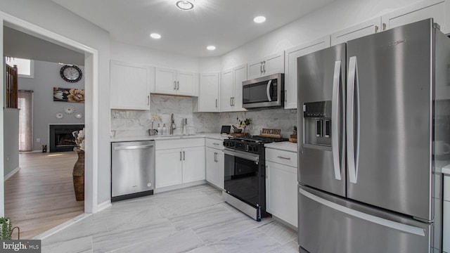 46932 Trumpet Cir, Sterling, VA 20164 - kitchen with stainless steel appliances, a sink, light countertops, backsplash, and white cabinets