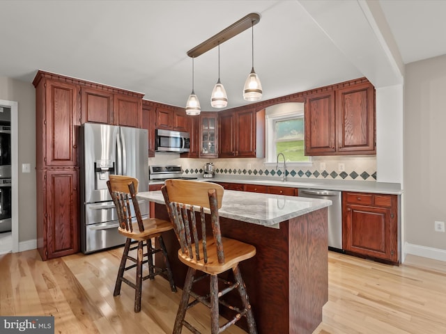 12943 Harford Rd, Hydes, MD 21082 - kitchen featuring appliances with stainless steel finishes, a sink, light wood-type flooring, and tasteful backsplash