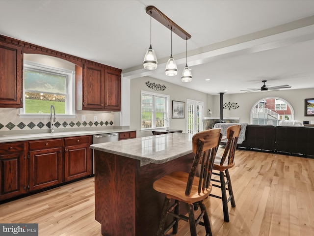 12943 Harford Rd, Hydes, MD 21082 - kitchen featuring light wood-style flooring, a sink, tasteful backsplash, open floor plan, and a breakfast bar