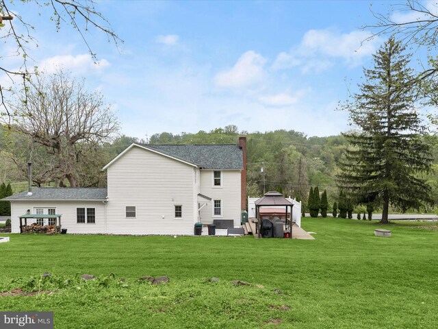 12943 Harford Rd, Hydes, MD 21082 - back of house with a gazebo, a lawn, a chimney, and roof with shingles