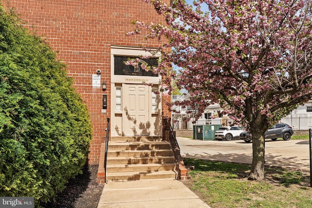 doorway to property featuring brick siding