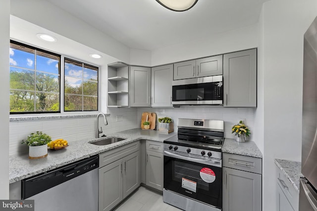 kitchen with a sink, gray cabinets, and stainless steel appliances