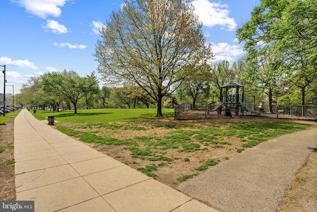 surrounding community with a lawn, a playground, and fence