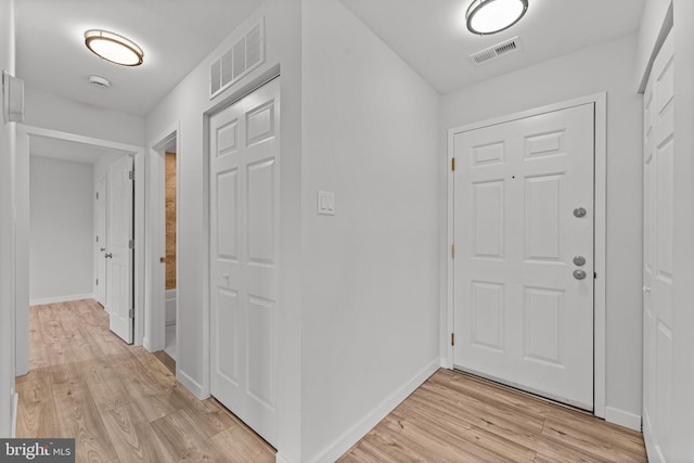 foyer with visible vents, baseboards, and light wood-type flooring