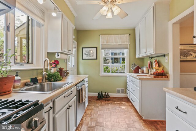 kitchen featuring a sink, appliances with stainless steel finishes, white cabinets, and visible vents