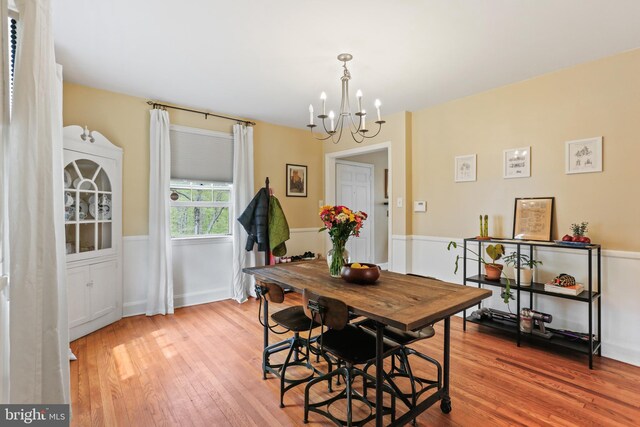 dining room featuring light wood-type flooring and a notable chandelier