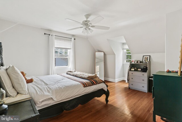 bedroom featuring baseboards, a ceiling fan, wood finished floors, and vaulted ceiling