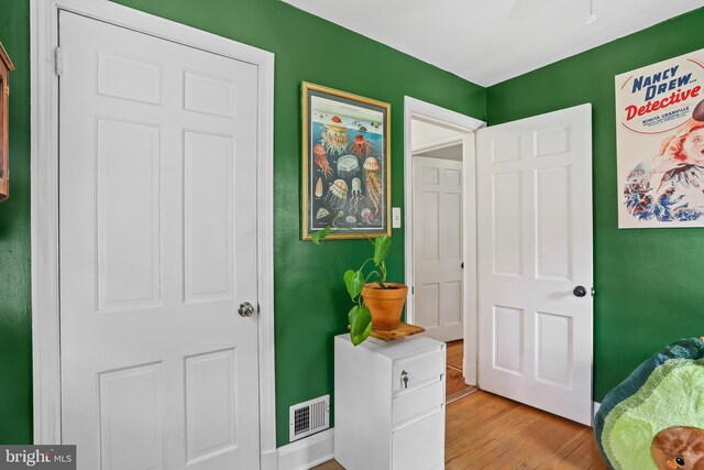 bedroom with light wood finished floors and visible vents