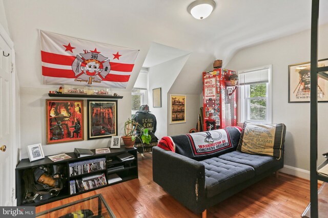 sitting room featuring baseboards, wood finished floors, and lofted ceiling