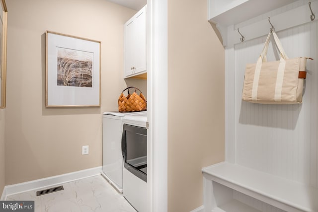 laundry room featuring visible vents, cabinet space, baseboards, marble finish floor, and washer and dryer