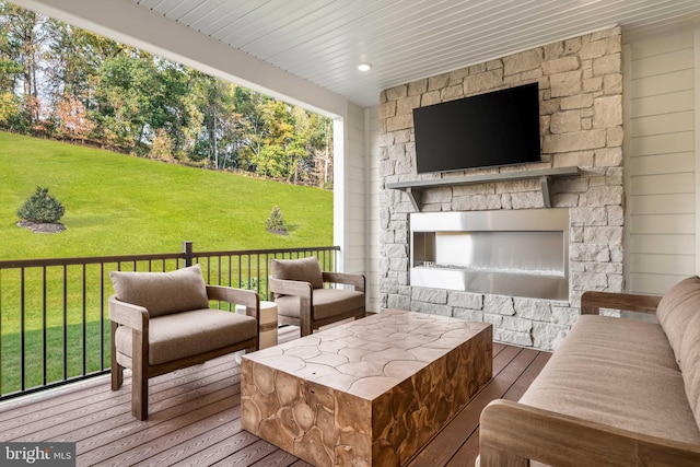deck featuring a yard and an outdoor living space with a fireplace