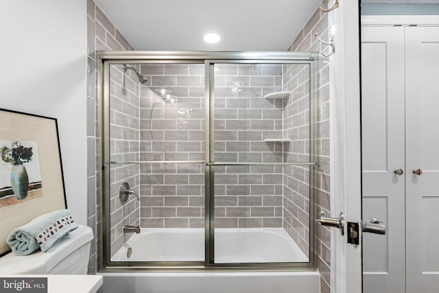 full bath with toilet, shower / bath combination with glass door, and recessed lighting