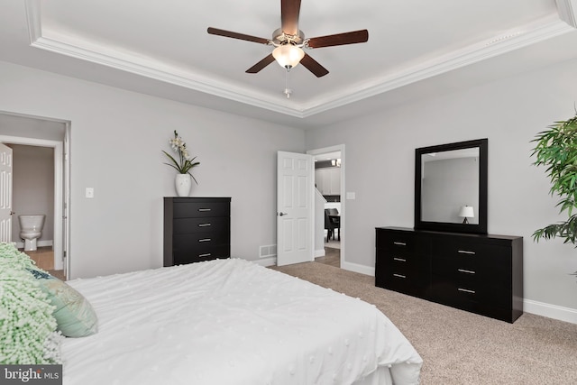 carpeted bedroom with visible vents, a raised ceiling, crown molding, and baseboards