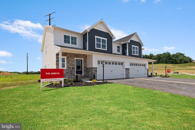 craftsman inspired home with aphalt driveway, board and batten siding, stone siding, and a front yard