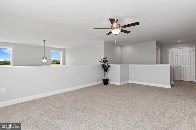 spare room featuring a ceiling fan, baseboards, plenty of natural light, and carpet