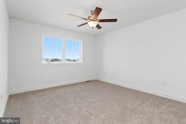 empty room featuring baseboards, a ceiling fan, and carpet flooring