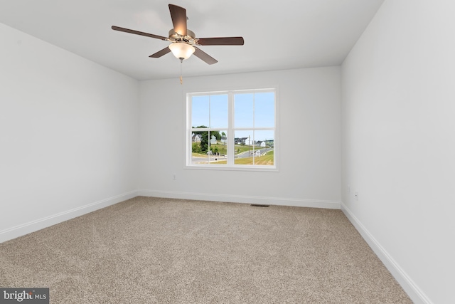 spare room featuring ceiling fan, visible vents, baseboards, and carpet