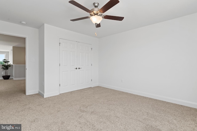 unfurnished bedroom with carpet floors, baseboards, ceiling fan, and a closet