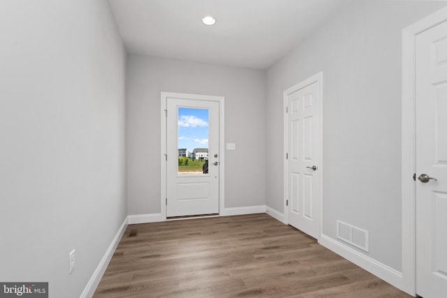 entryway with baseboards, visible vents, and wood finished floors