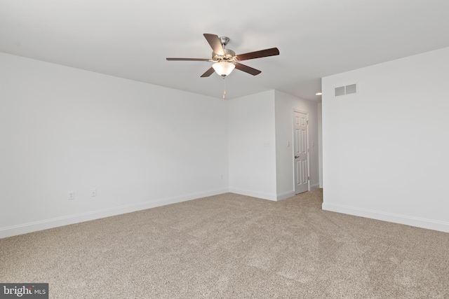 spare room with visible vents, baseboards, ceiling fan, and light carpet
