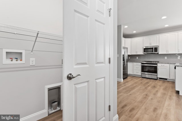 laundry area with laundry area, light wood-type flooring, baseboards, hookup for a washing machine, and recessed lighting