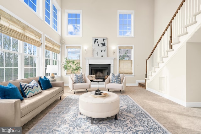living area with stairs, a high ceiling, and a wealth of natural light